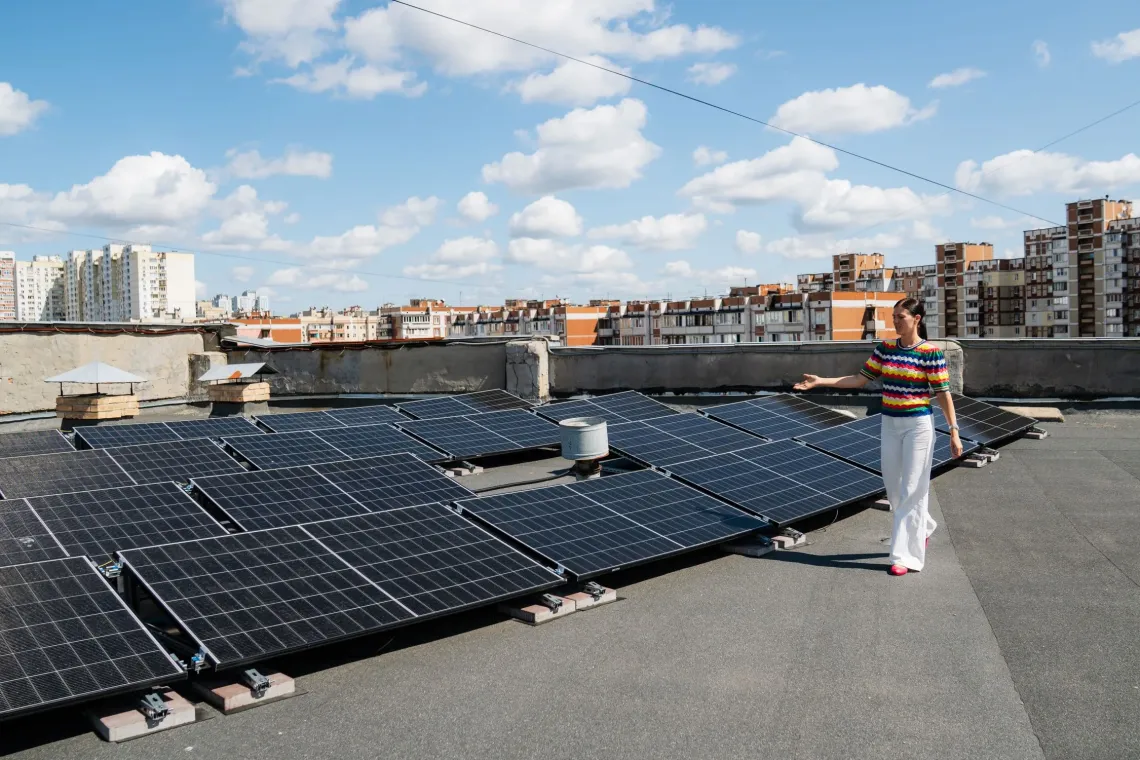 A woman showing solar panels on the roof of the hospital.