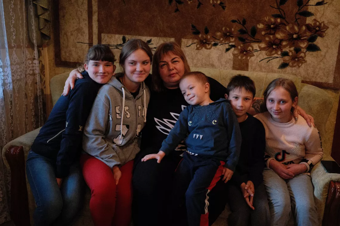 A family sits on their couch.