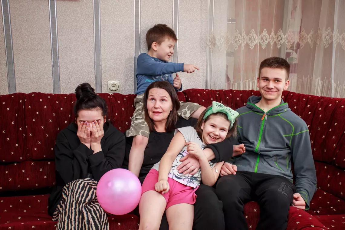 A family sits on their couch.