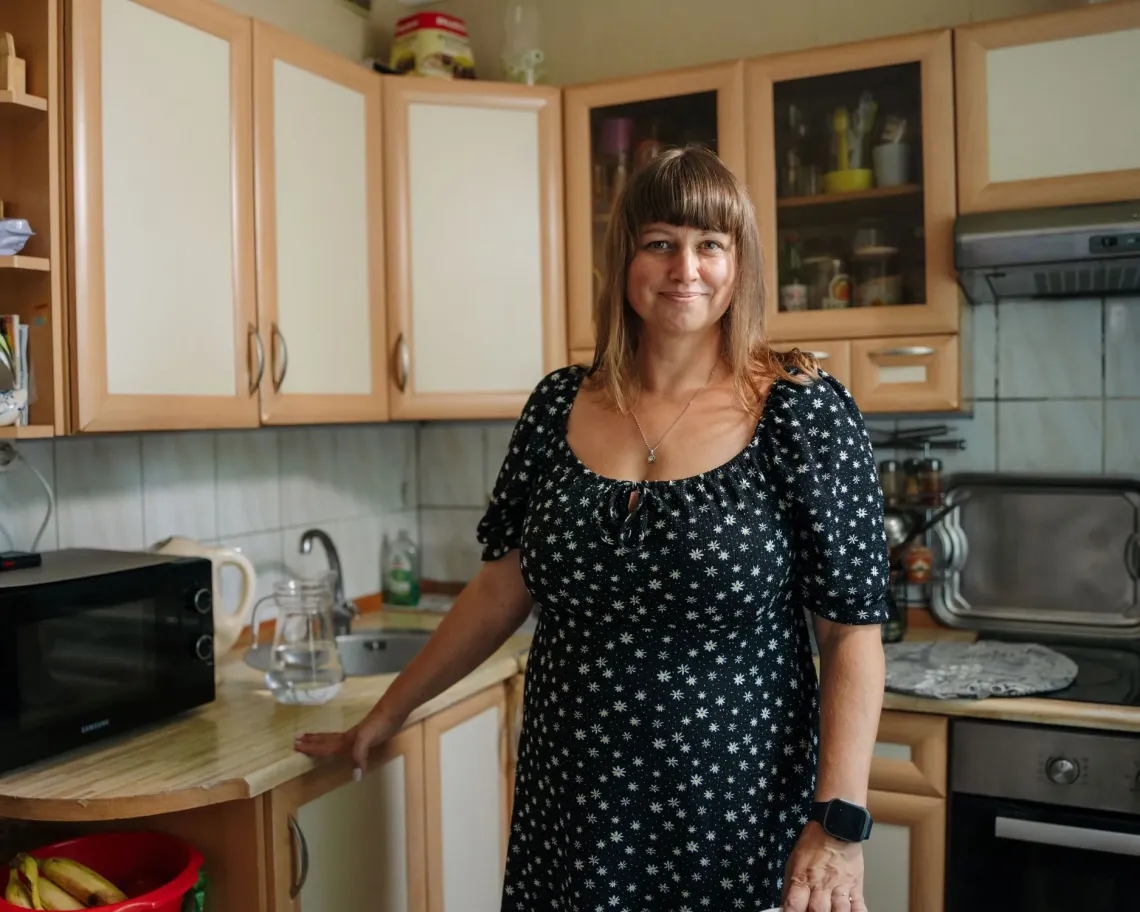 A woman standing in her kitchen