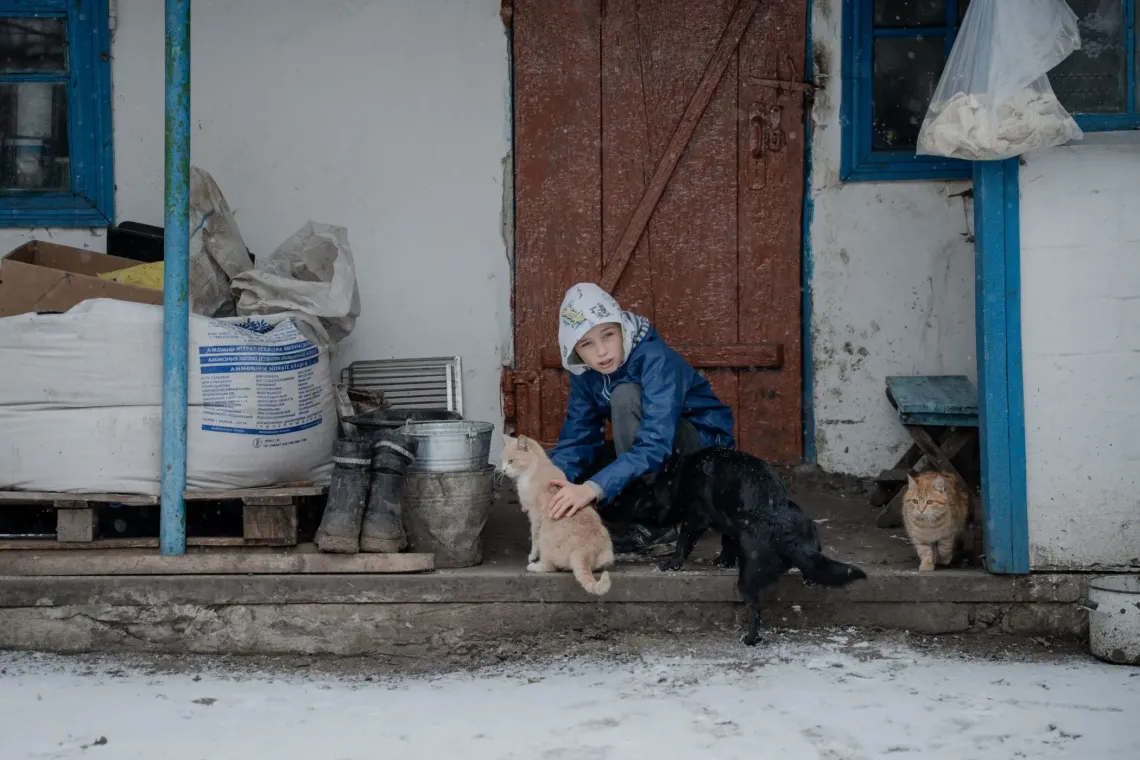 A boy with a kitten near the private house in eastern Ukraine