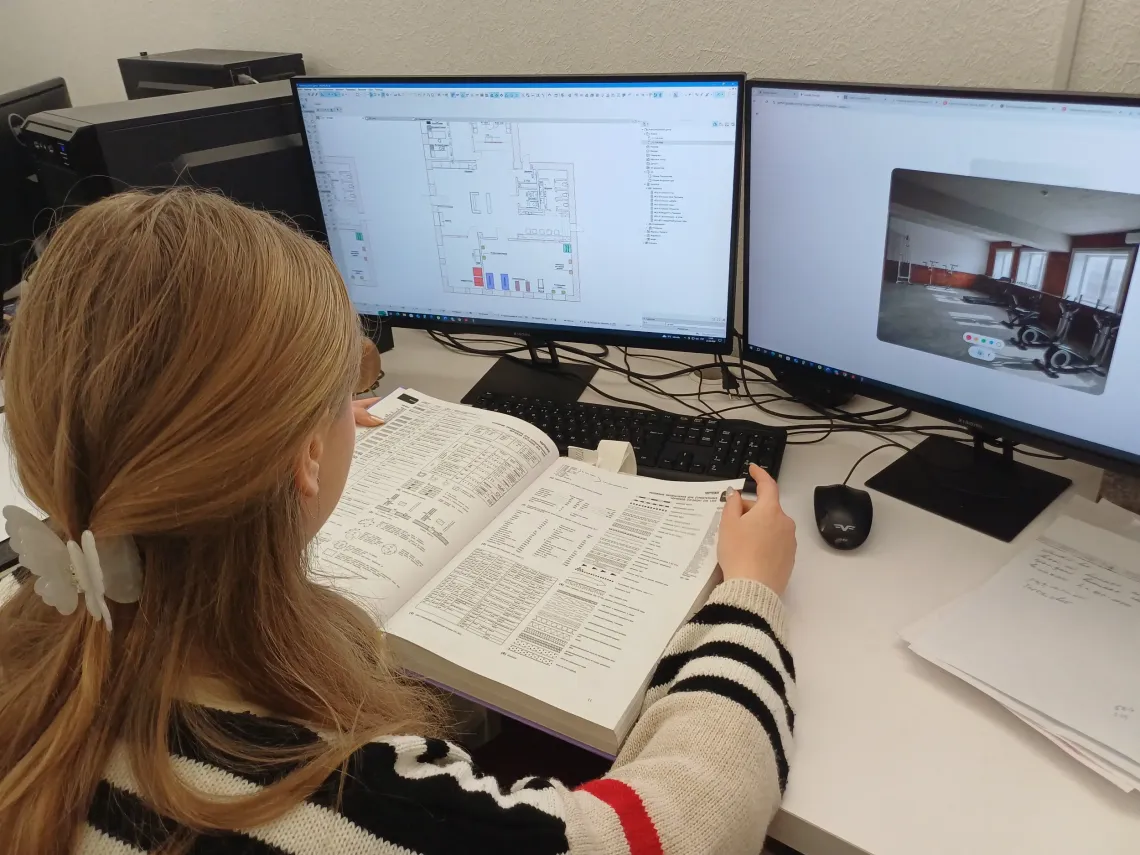 A teenage girl sitting at her computer during internship.