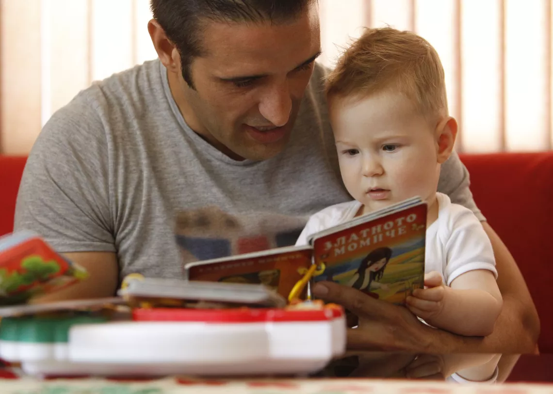 Father is reading to his 2-year-old child