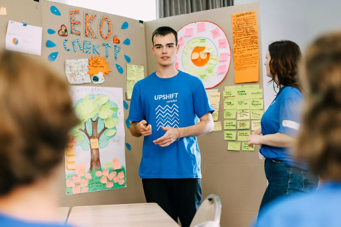 Підліток у футболці UPSHIFT презентує еко-проєкт