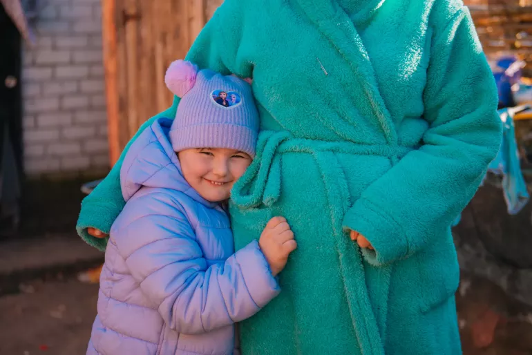 Five-year-old Karolina from Kharkiv oblast hugs her mother