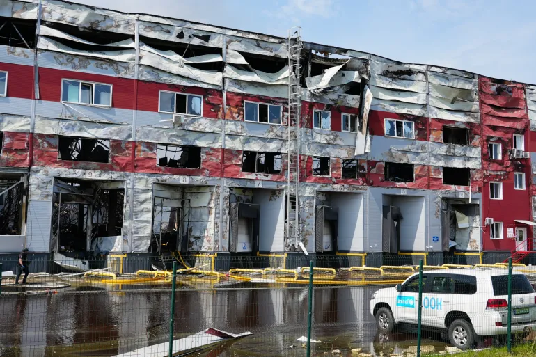 Damaged UNICEF-contracted warehouse in Kyiv region with a UNICEF vehicle in front