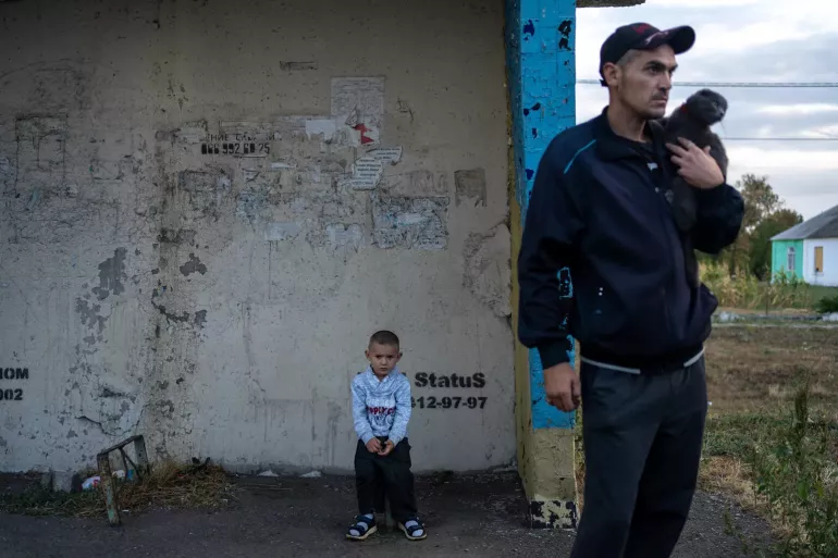 Ukraine. A boy sits on a broken bench at a bus stop in the village of Dachne, eastern Ukraine, waiting for a bus that will evacuate displaced families to the city of Pavlohrad.