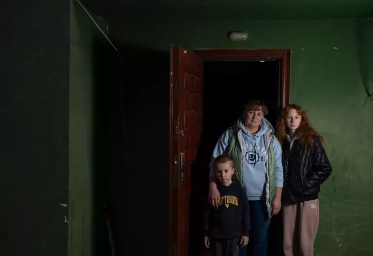 Katya, her five-year-old son Andriy, and 14-year-old daughter Halyna stand together in their rented house in Khotimlya, Kharkiv region. Displaced by the war in Ukraine, they try to adapt to their new surroundings while preparing for a challenging winter. 