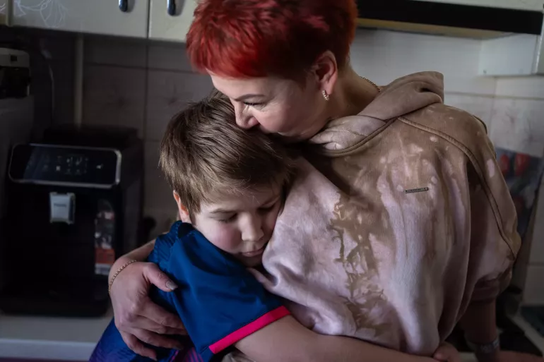 Mother hugs her son