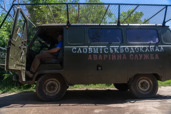 A Slovmiskvodokanal service vehicle covered with protective netting.