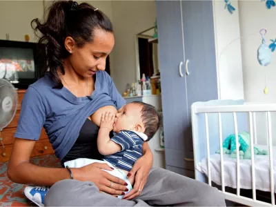 Un beb&eacute; toma la teta mientras mira a su madre, que tambi&eacute;n lo mira.