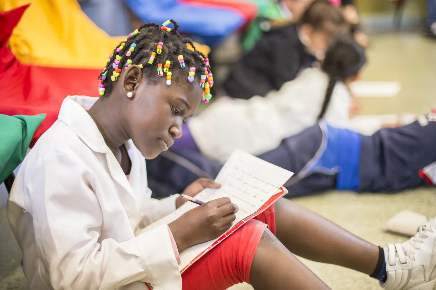 Una ni&ntilde;a migrante en Uruguay escribe en un cuaderno