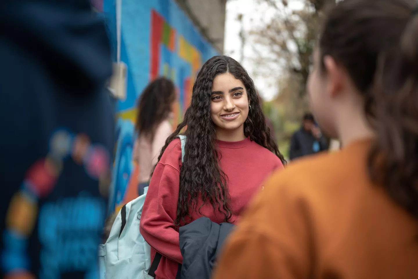 Adolescente mujer, al aire libre, sonriendo.