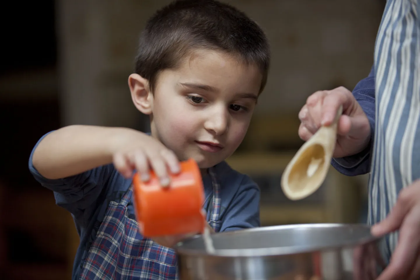 Ni&ntilde;o cocina junto a un adulto.