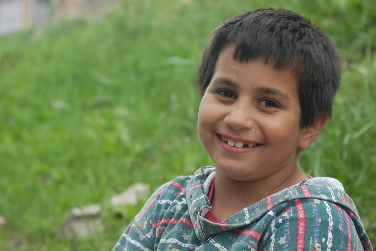 Var&oacute;n de unos 10 a&ntilde;os sonriendo a c&aacute;mara, al aire libre