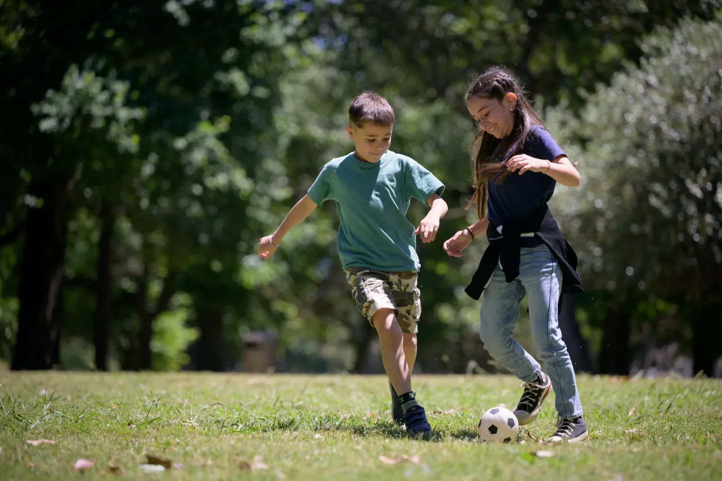 Ni&ntilde;o y ni&ntilde;a jugando al f&uacute;tbol