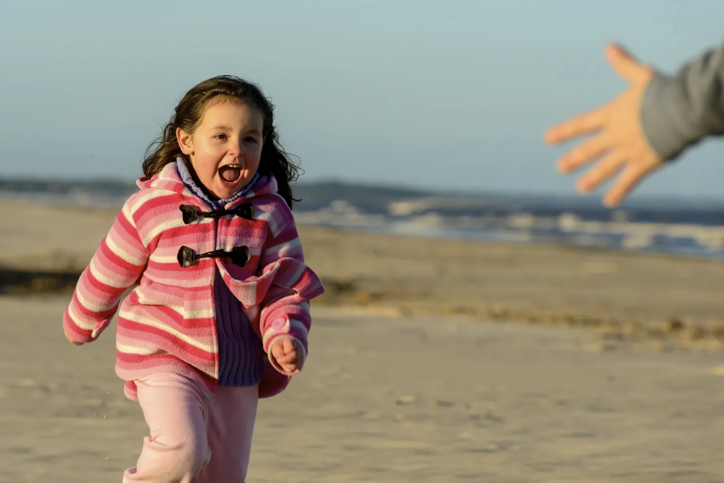 Ni&ntilde;a de unos 4 a&ntilde;os, corriendo en la playa.