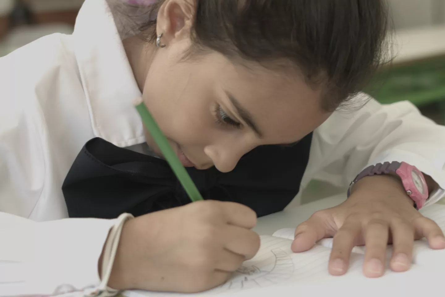 Ni&ntilde;a escolar escribiendo en un cuaderno