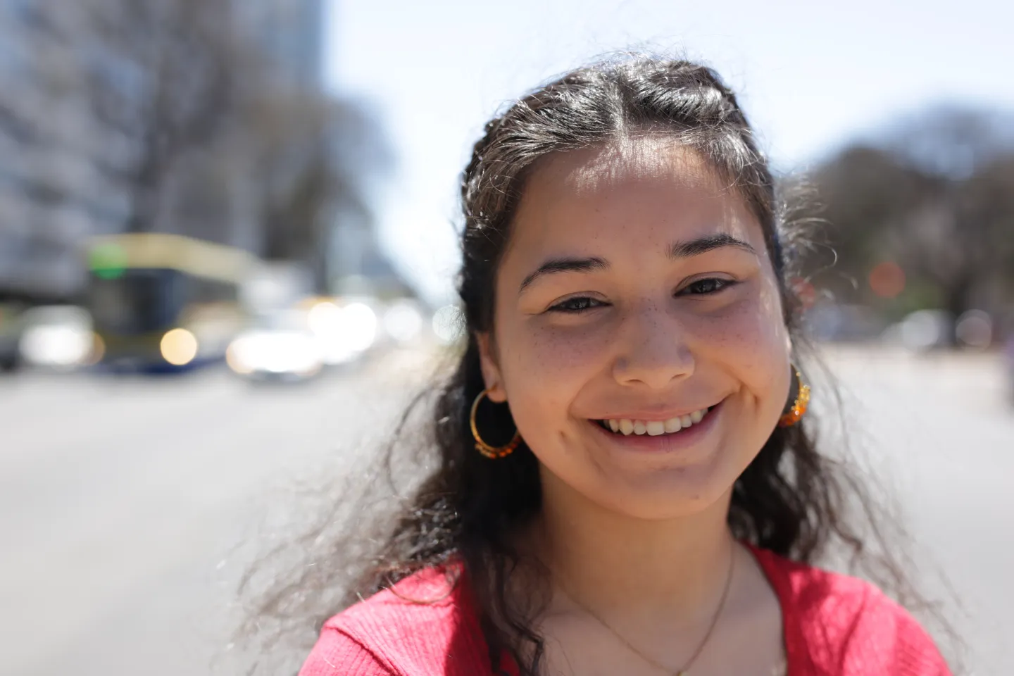 Adolescente mujer, en la calle, sonriendo a c&aacute;mara.