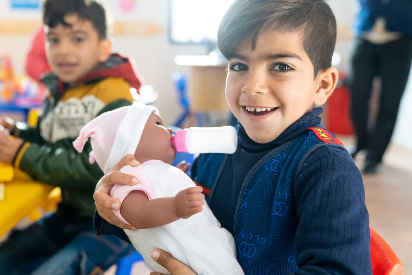 Ni&ntilde;o, sosteniendo un beb&eacute; de juguete.