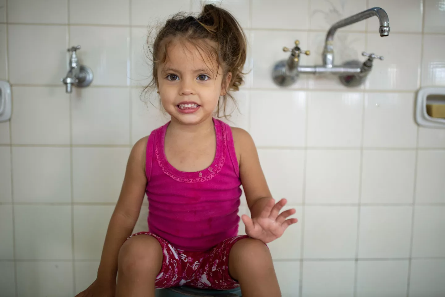 Ni&ntilde;a, sentada sobra balde.