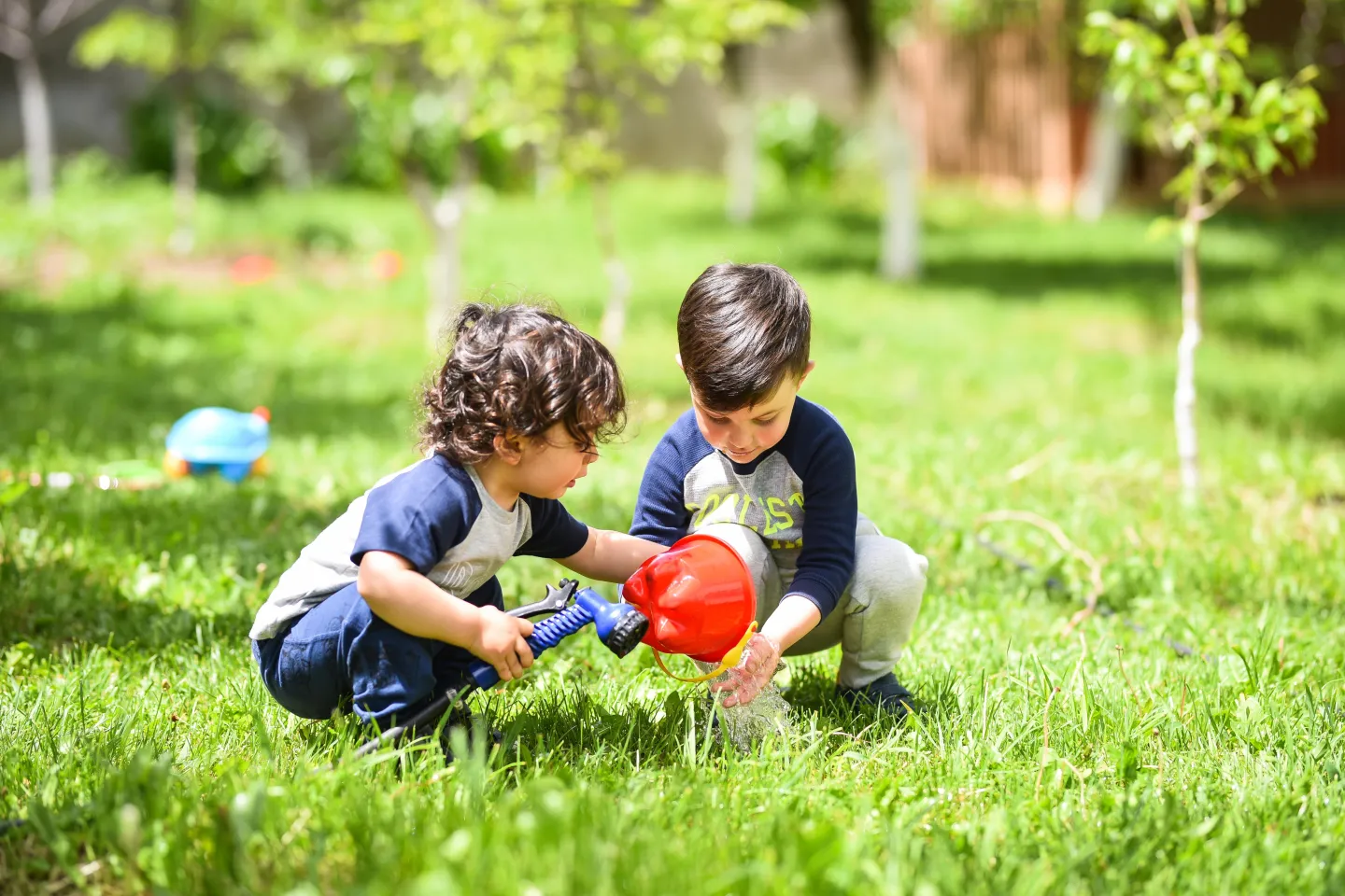 Dos ni&ntilde;os, de entre uno y 2 a&ntilde;os, jugando en el pasto.