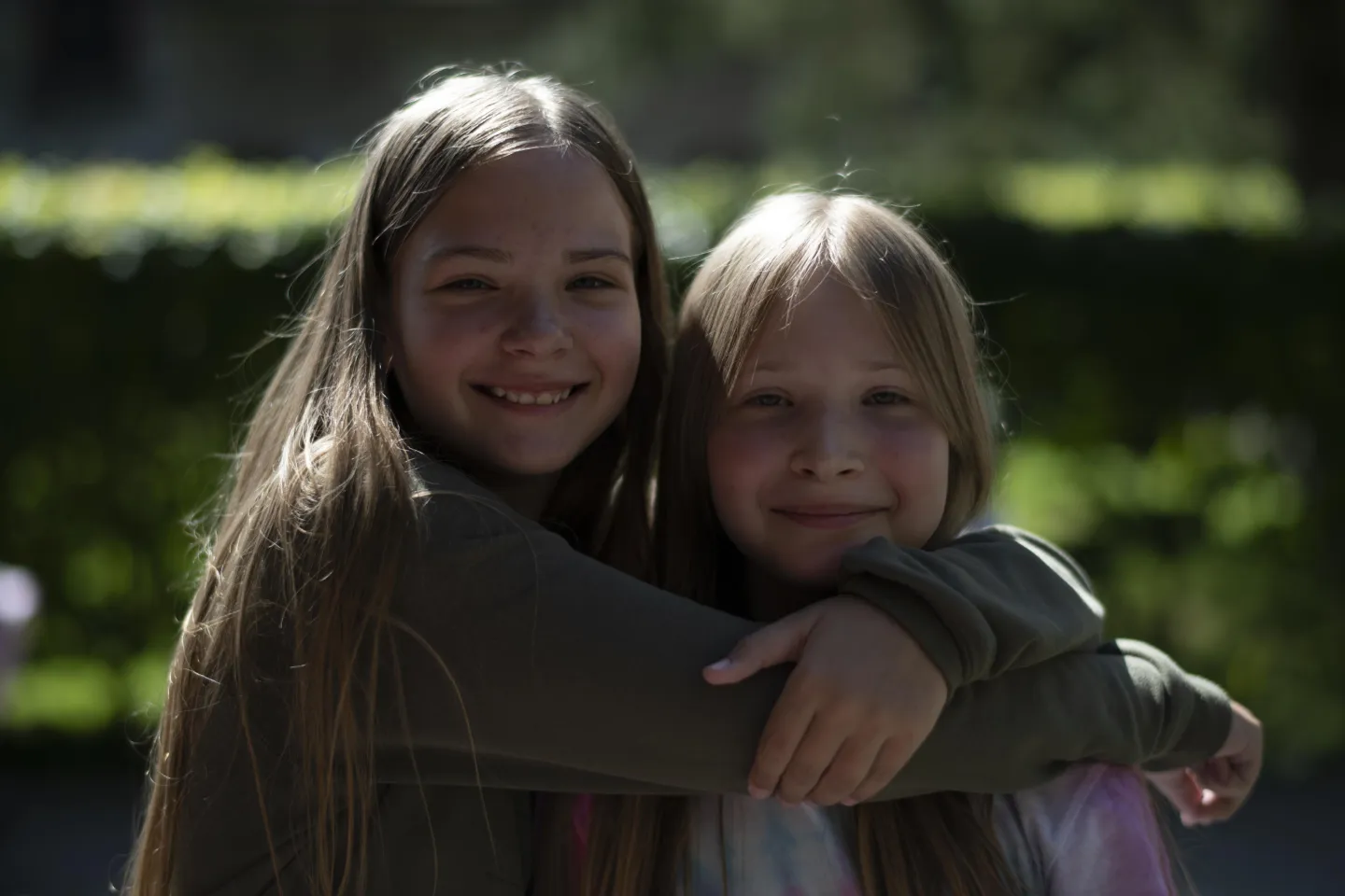 Dos ni&ntilde;as, de 9 y 11 a&ntilde;os, abraz&aacute;ndose y sonriendo a c&aacute;mara.