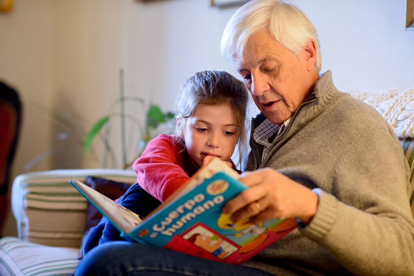 Abuelo y nieta leen juntos un cuento