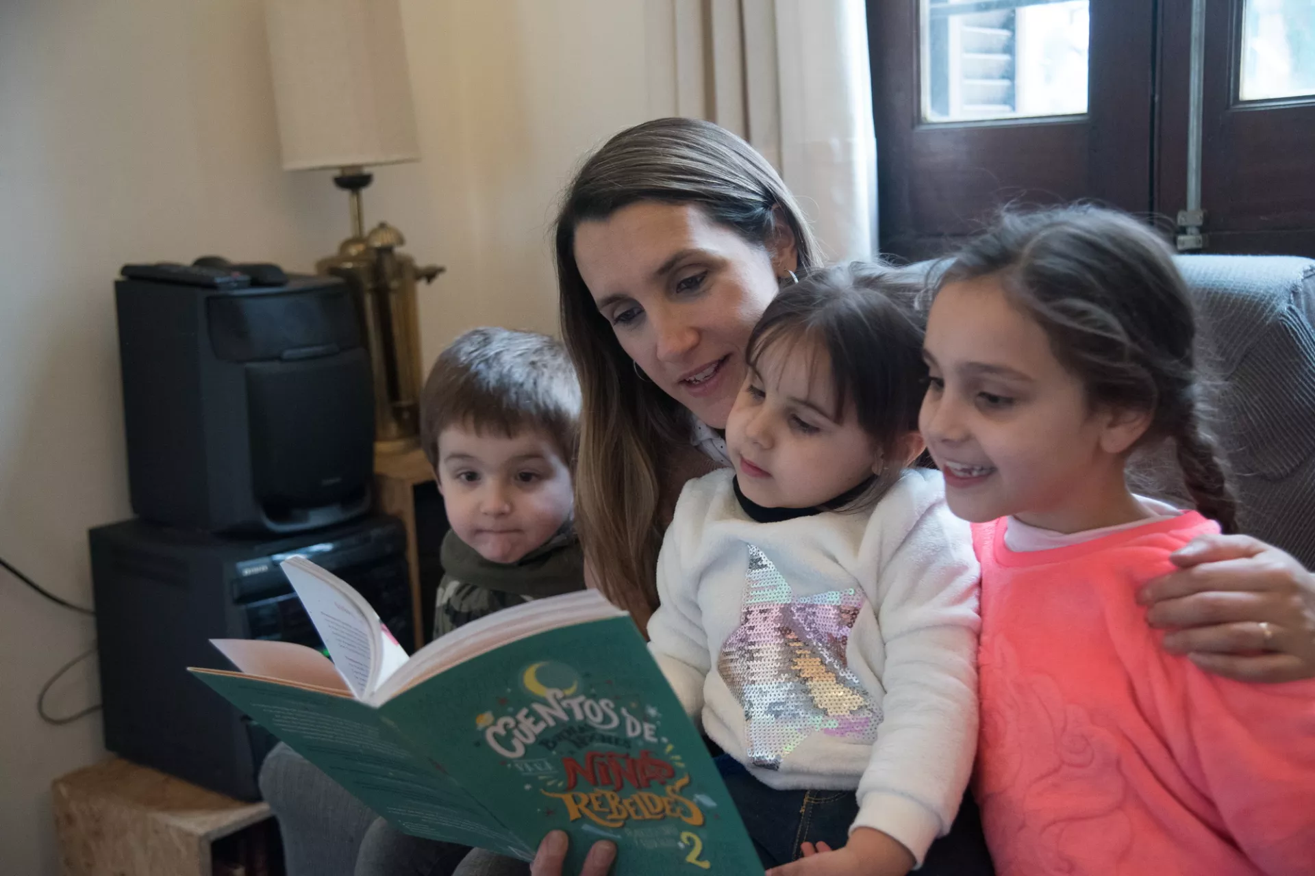 Malena y sus hijos leen juntos un libro