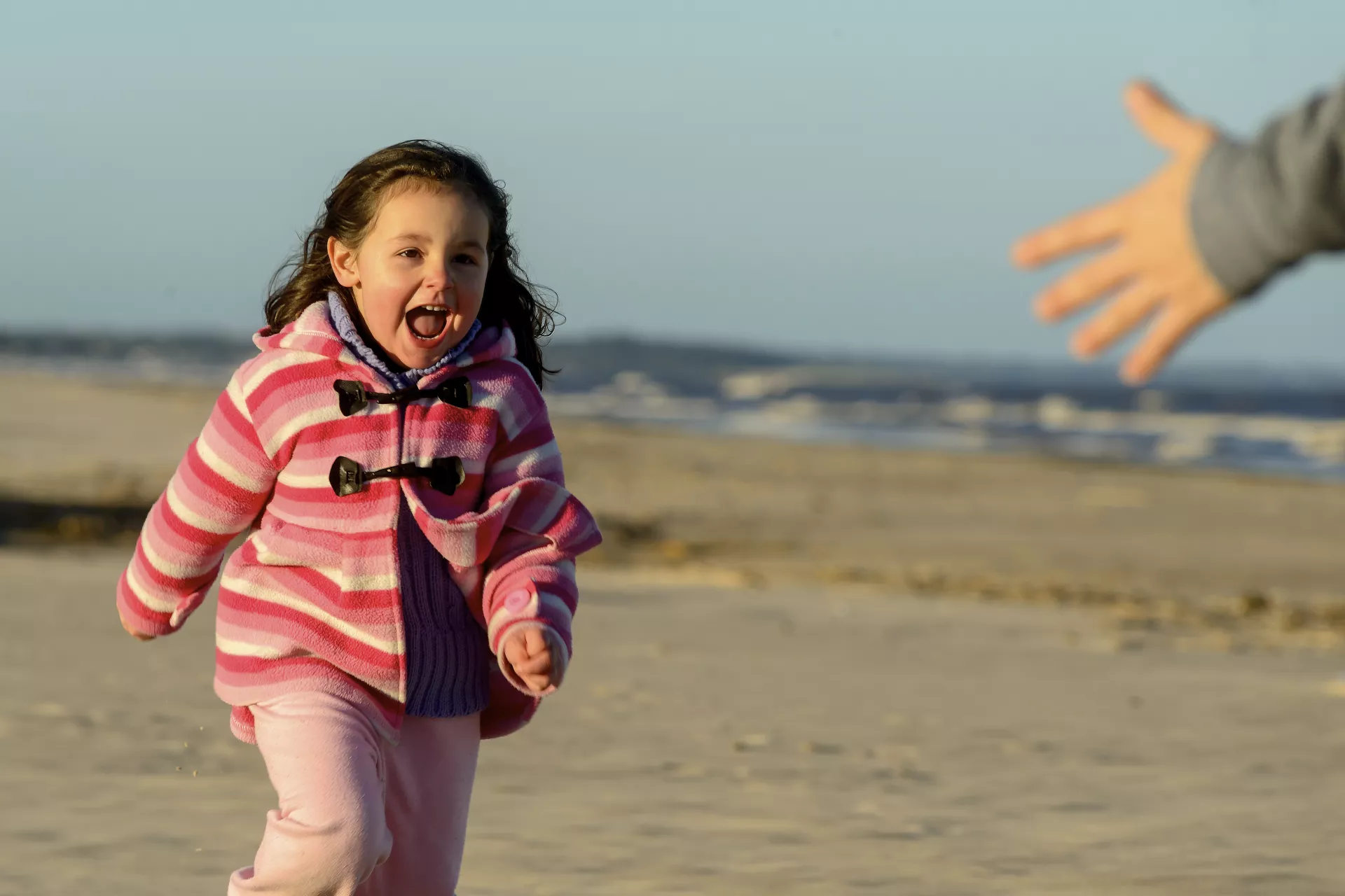 Ni&ntilde;a de unos 4 a&ntilde;os, corriendo en la playa.