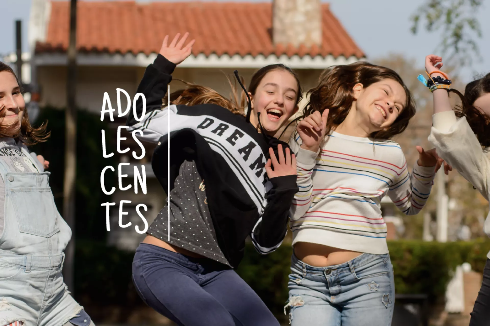 Cuatro adolescentes mujeres en una plaza saltando