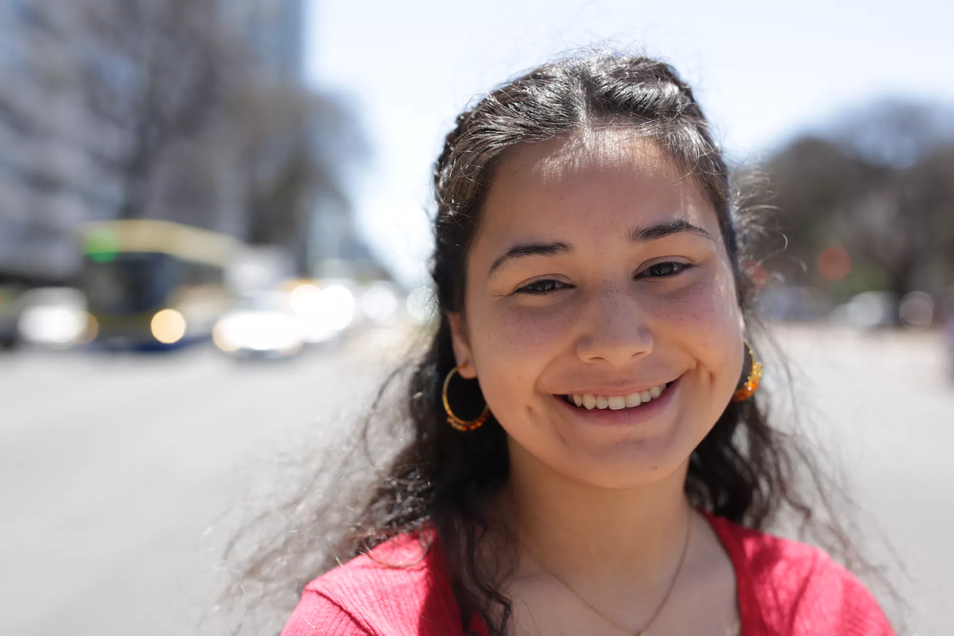 Adolescente mujer, en la calle, sonriendo a c&aacute;mara.