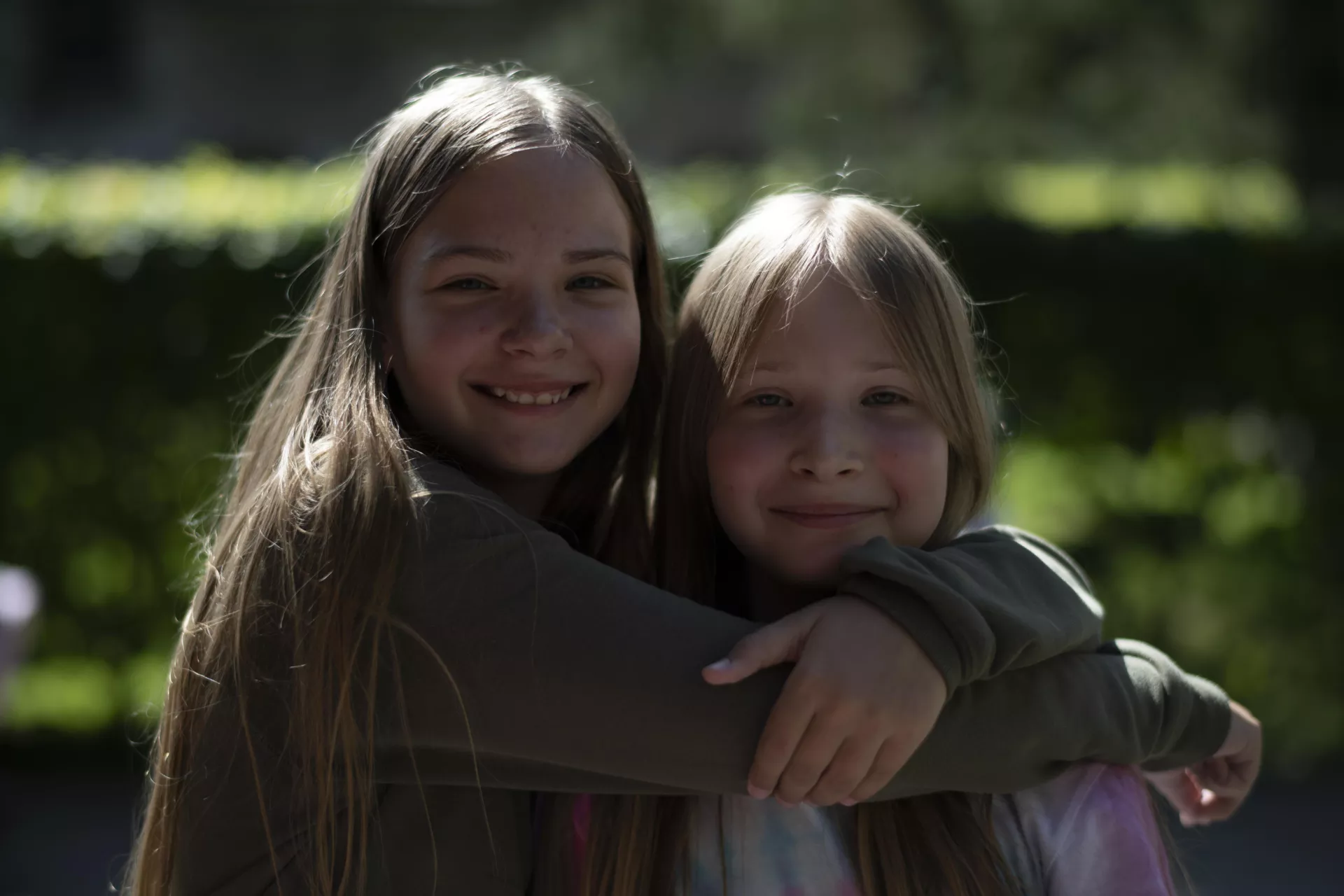 Dos ni&ntilde;as, de 9 y 11 a&ntilde;os, abraz&aacute;ndose y sonriendo a c&aacute;mara.