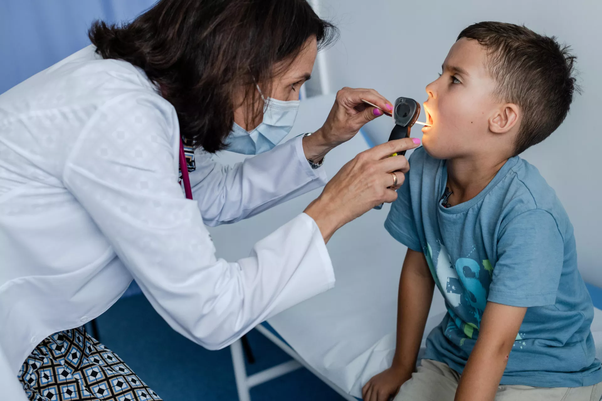 Doctora revisando la garganta de un ni&ntilde;o.