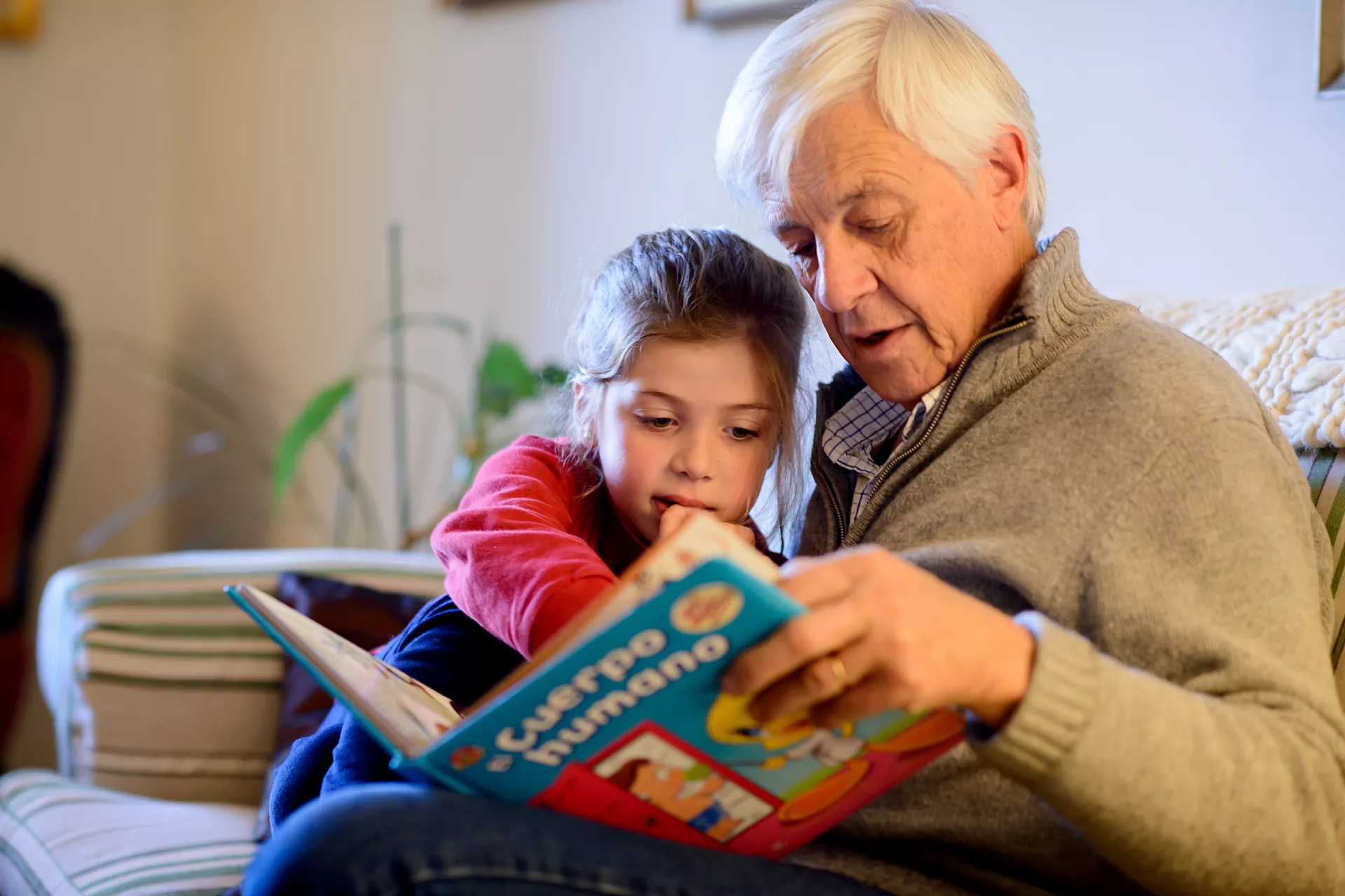 Abuelo y nieta leen juntos un cuento