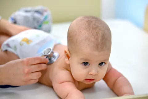 Bebé siendo auscultado con un estetoscopio.