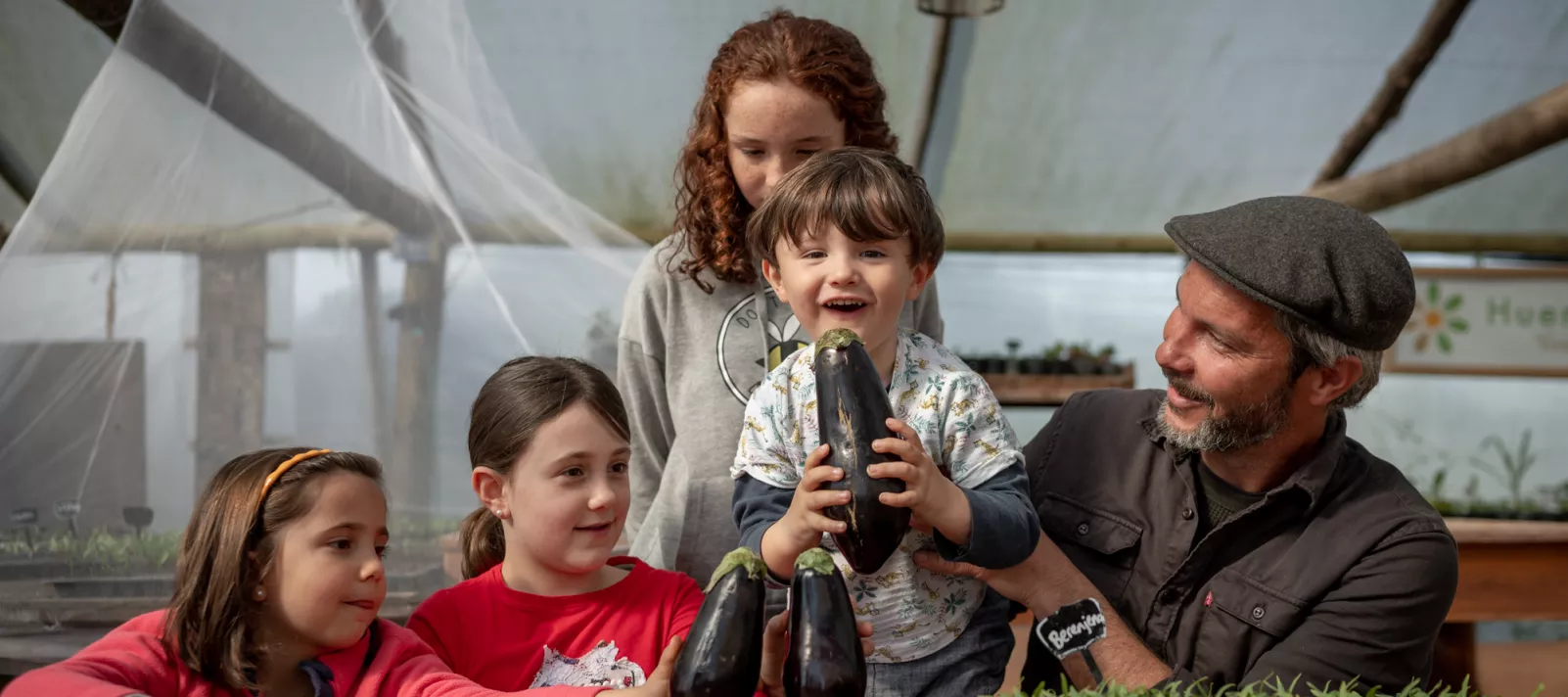 Hombre y 4 ni&ntilde;os. Uno de ellos est&aacute; sosteniendo una berenjena