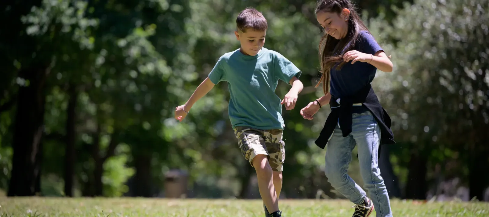 Ni&ntilde;o y ni&ntilde;a jugando al f&uacute;tbol