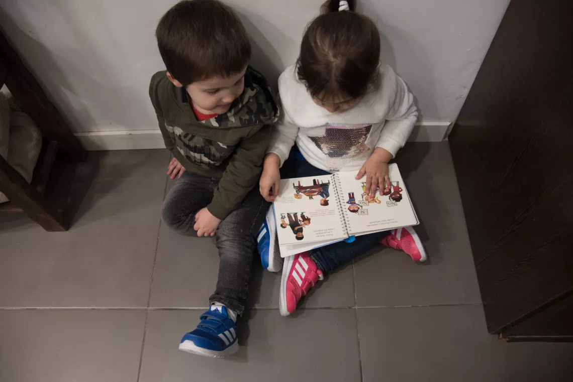 Los mellizos, hijos de Malena, leen juntos un libro