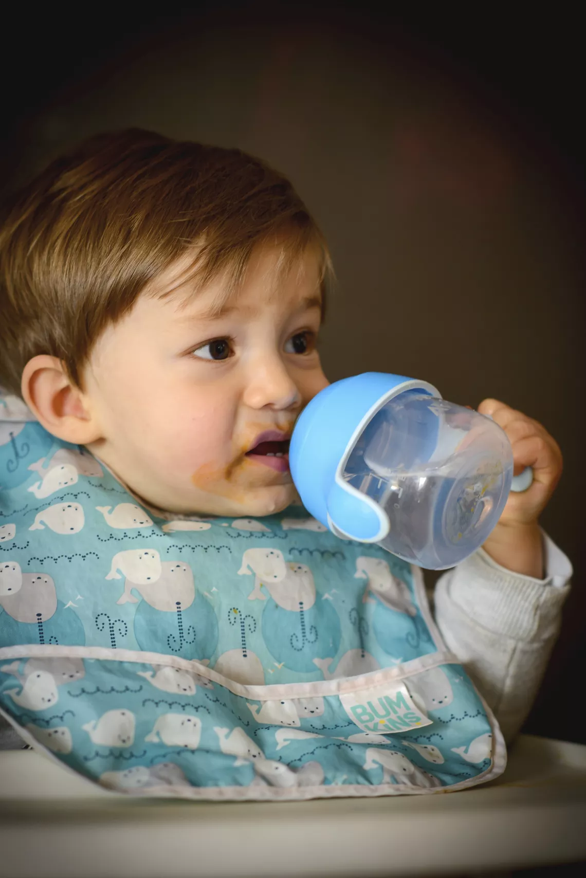 Ni&ntilde;o de unos 8 meses tomando agua de vasito para beb&eacute;s.