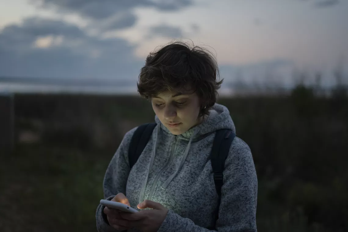 Adolescente mujer, al aire libre, con celular
