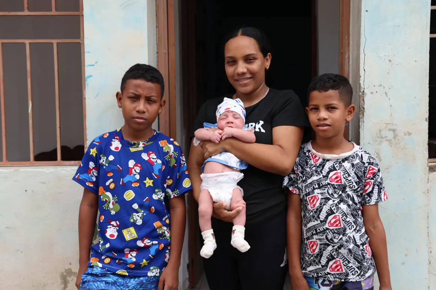 Thomas, 11, and Mathias, 8, accompanied by their mother, Wilnelis, and their baby sister, in front of their home in G&uuml;iria, Sucre state, Venezuela, on June, 24, 2025.  