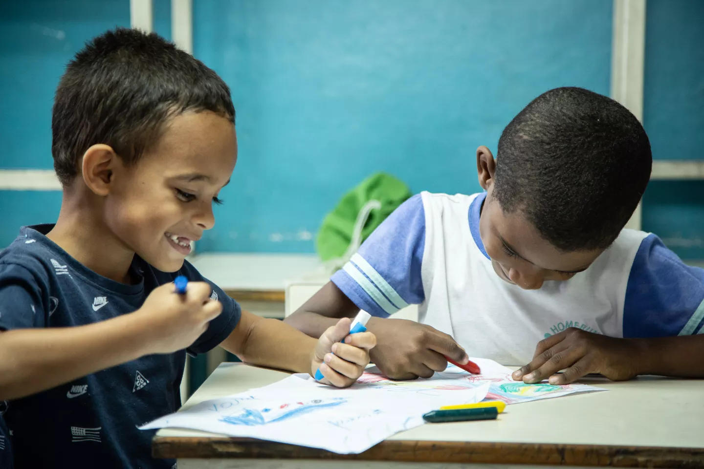 Ni&ntilde;os dibujando en sobre una mesa