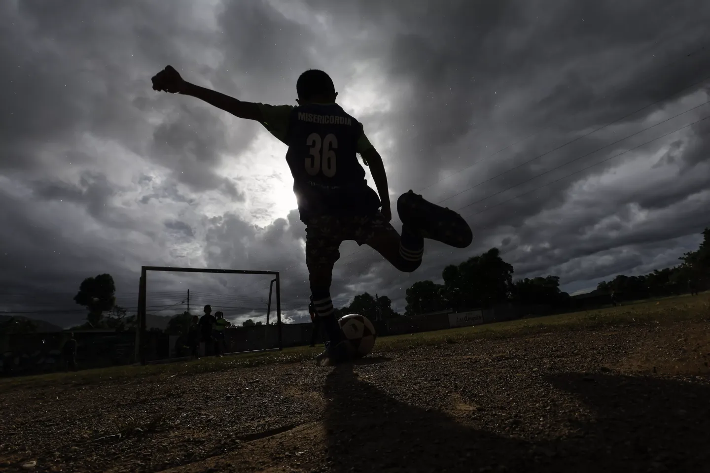 Un ni&ntilde;o de la escuela Misericordia F.C., patea un bal&oacute;n de f&uacute;tbol hacia la porter&iacute;a durante su pr&aacute;ctica en el campo de entrenamiento, en el barrio Canchunch&uacute;, Car&uacute;pano, estado Sucre, Venezuela, el viernes 3 de noviembre de 2023.