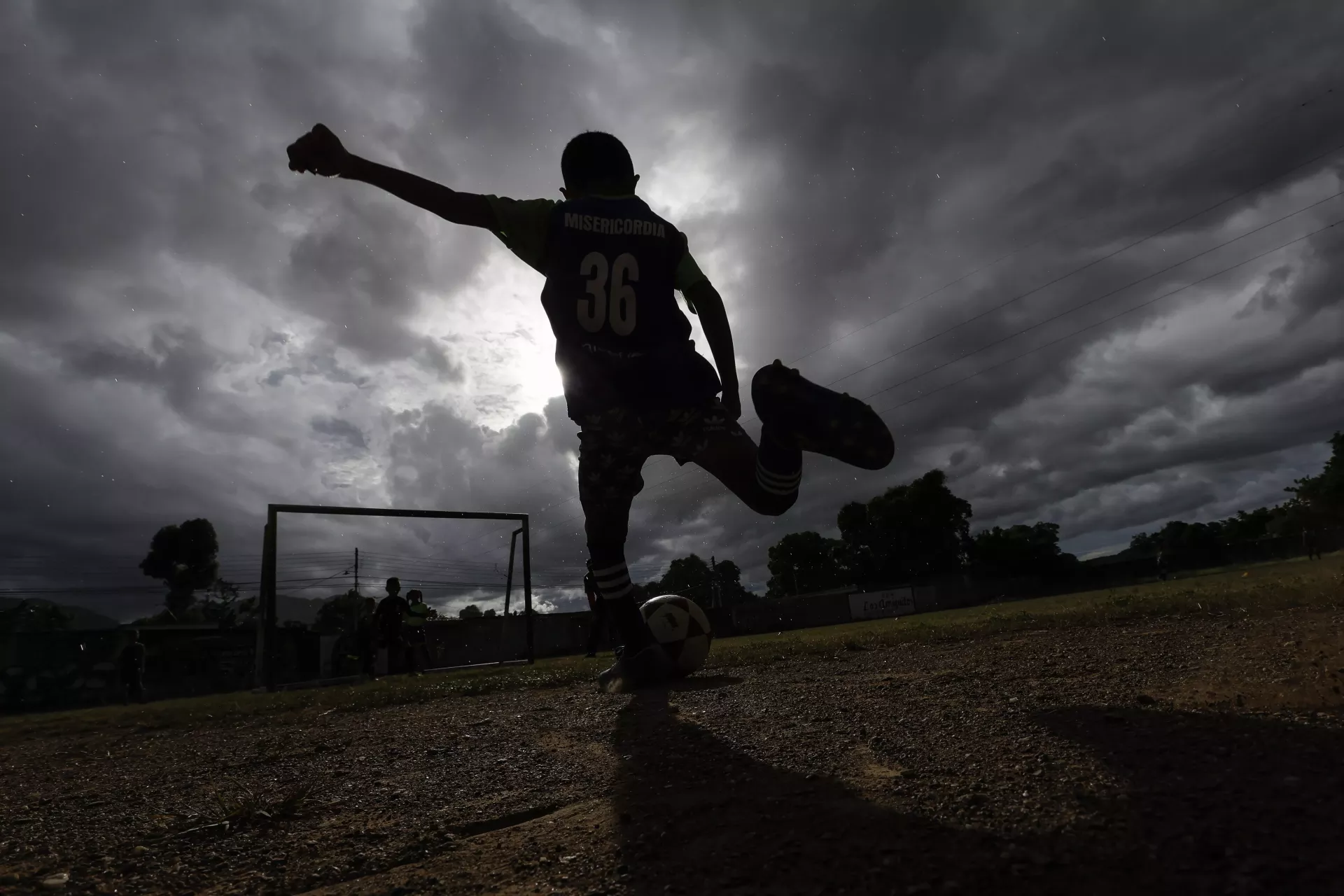 Un ni&ntilde;o de la escuela Misericordia F.C., patea un bal&oacute;n de f&uacute;tbol hacia la porter&iacute;a durante su pr&aacute;ctica en el campo de entrenamiento, en el barrio Canchunch&uacute;, Car&uacute;pano, estado Sucre, Venezuela, el viernes 3 de noviembre de 2023.