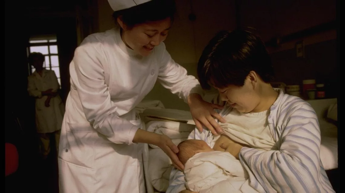 En 1993, una enfermera ayuda a una mam&aacute; para que amamante a su beb&eacute; en la sala de maternidad de un hospital apoyado por UNICEF, en Beijing.