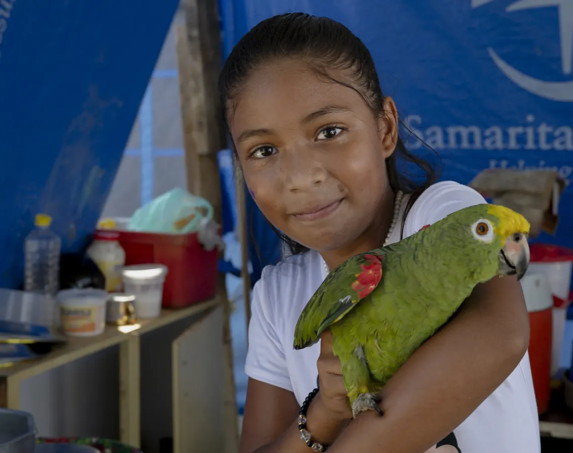 Derwimar sostiene a Panchito, el loro que la acompa&ntilde;a en el campamento. 