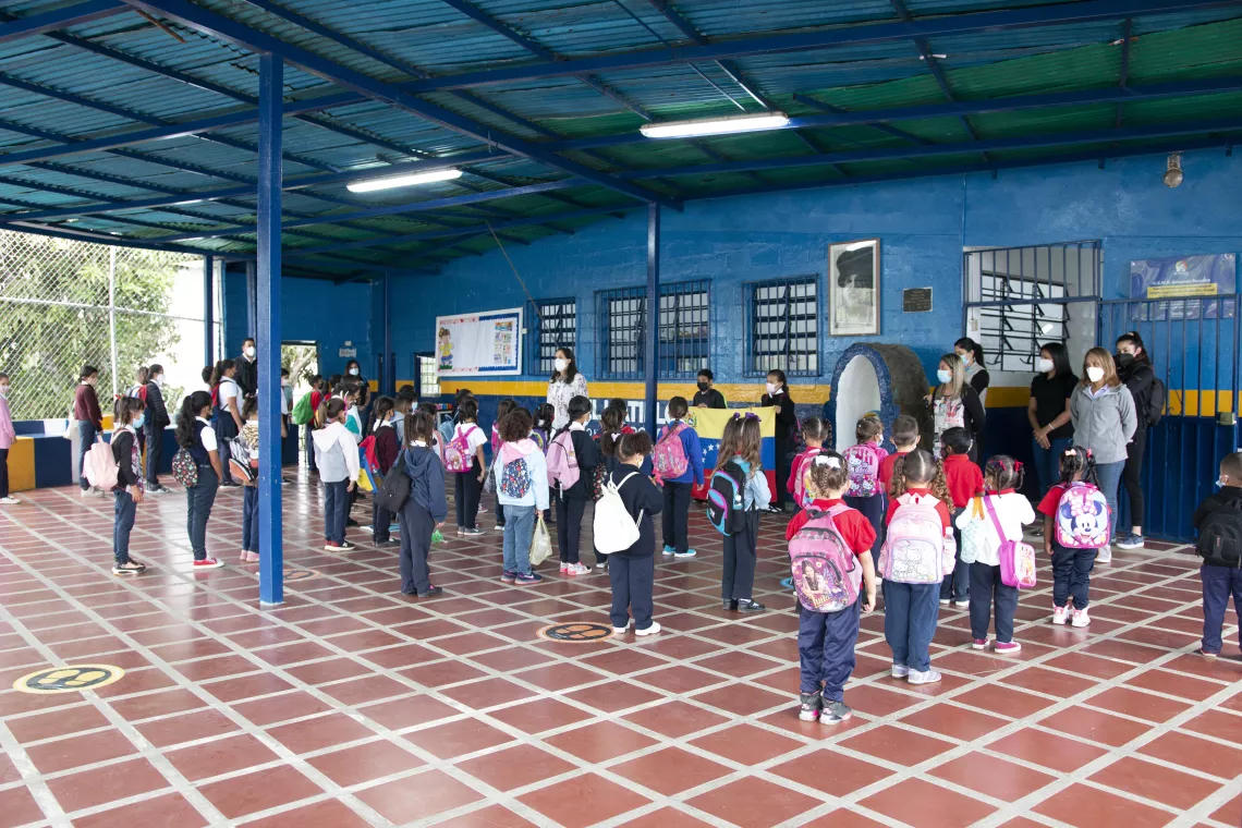 Preschool and elementary school children line up to sing the national anthem before entering classrooms.