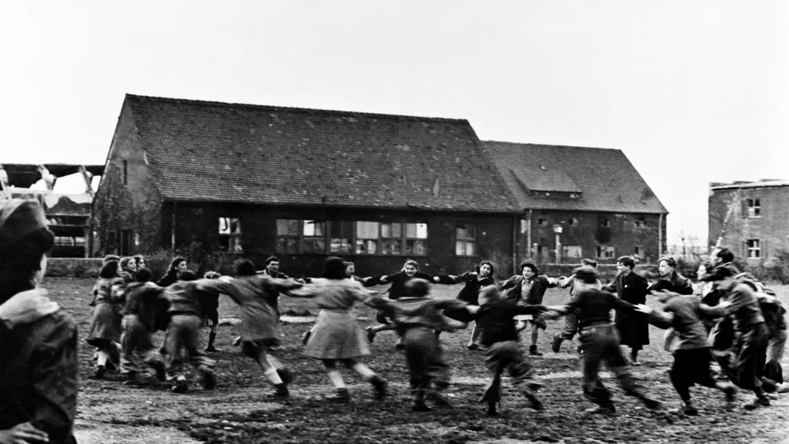En 1946, en Alemania, ni&ntilde;os y ni&ntilde;as -quienes en su mayor&iacute;a hab&iacute;an perdido a sus padres en los campos de concentraci&oacute;n realizan una danza folcl&oacute;rica en un campo de telecomunicaciones del ej&eacute;rcito.