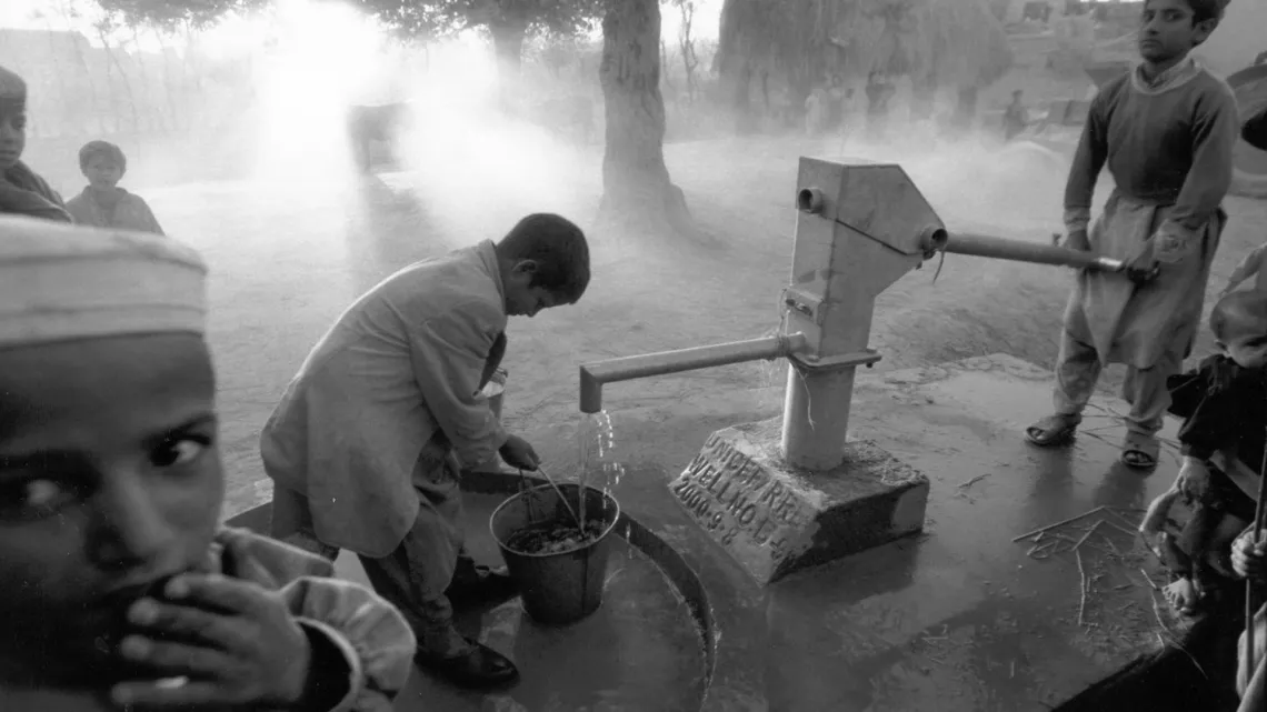 En 2000 en Afganist&aacute;n, ni&ntilde;os recogen agua a trav&eacute;s de una bomba manual en las afueras de la ciudad de Laghman.